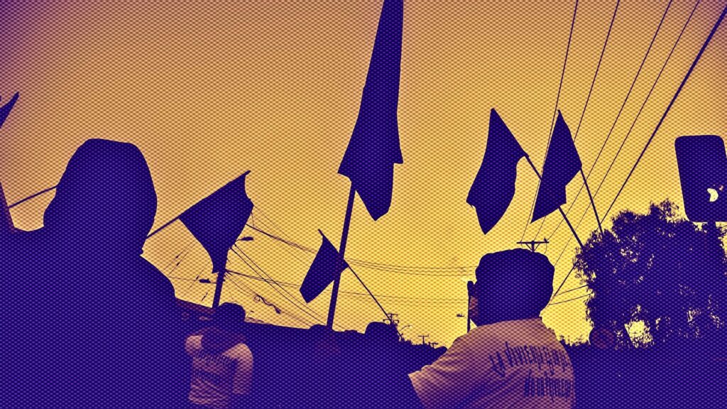 Personas en una marcha alzando banderas