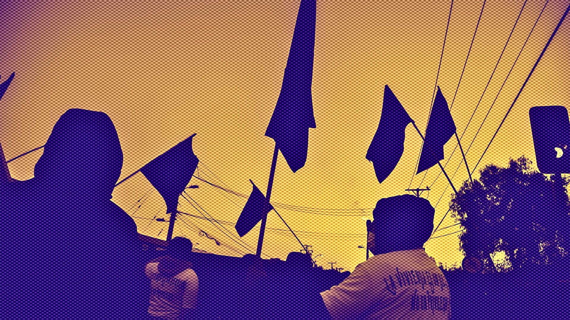 Personas en una marcha alzando banderas